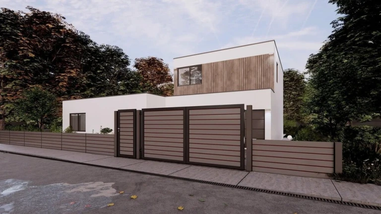 A modern white house with a brown slatted fence, a gate, and a small gate at the edge of the forest.