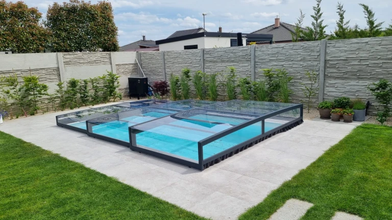 A modern, low-profile pool cover with a transparent panel in the garden