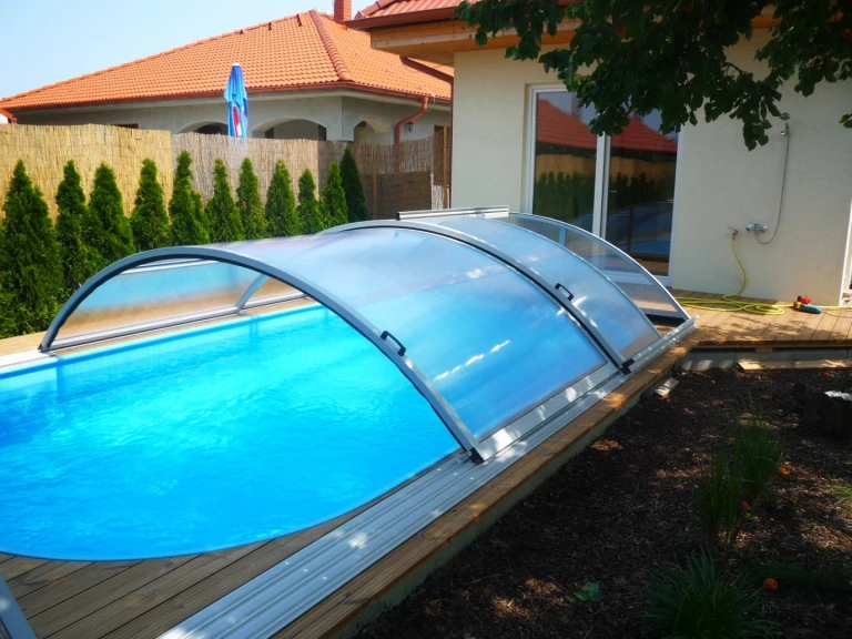 A KLASIK semi-circular pool cover with bright blue water in the garden of a single-family home in Hrubý Šúr.
