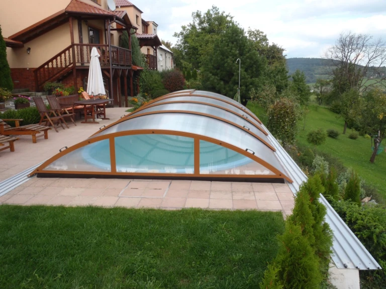 A closed arched canopy over the pool on the terrace of a single-family home.