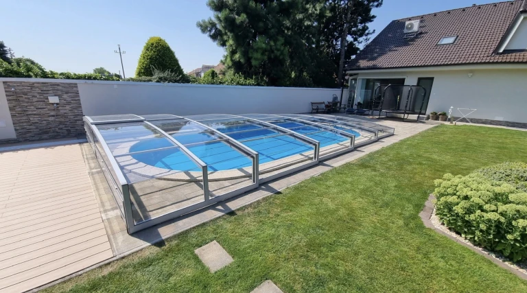 A modern, low-profile telescopic pool enclosure in the garden of a single-family home