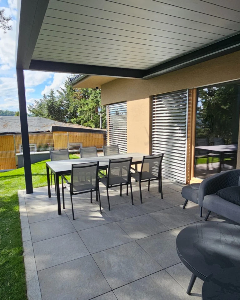 A modern bioclimatic pergola with garden seating on the terrace of a single-family home