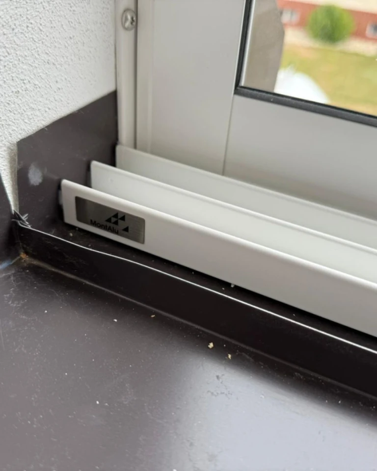 A close-up view of the bottom guide rail and the seal on the aluminum glazing profile featuring the MontAl logo.