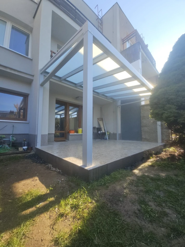 A modern white aluminum pergola with frosted glass, built on the terrace of a single-family home