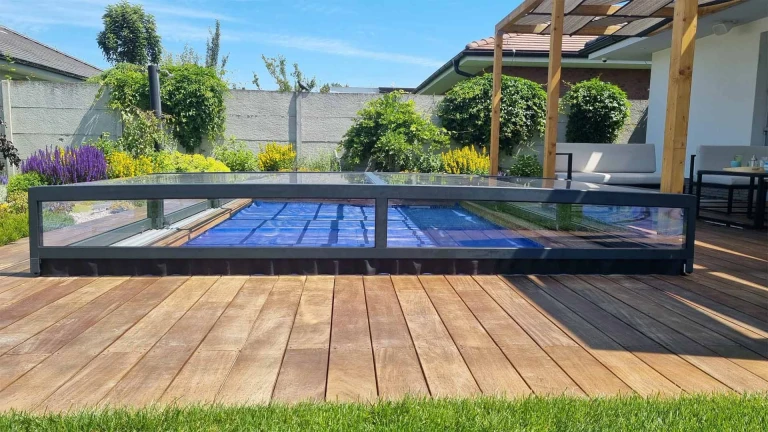 A modern, low-profile pool canopy on a wooden deck in the garden