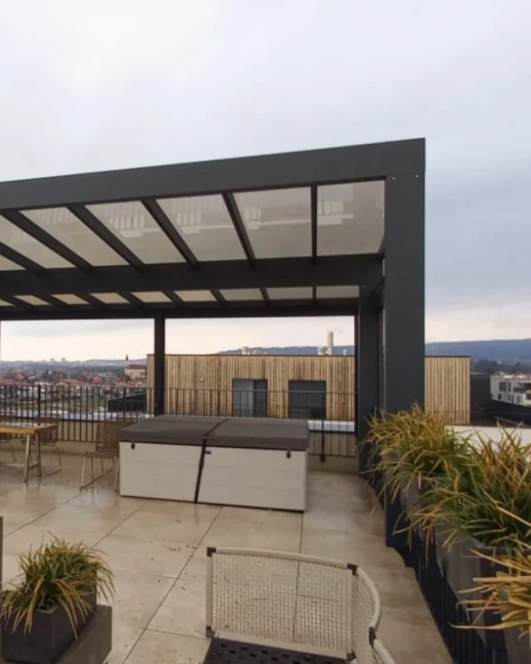 A modern aluminum pergola on a rooftop terrace overlooking the city