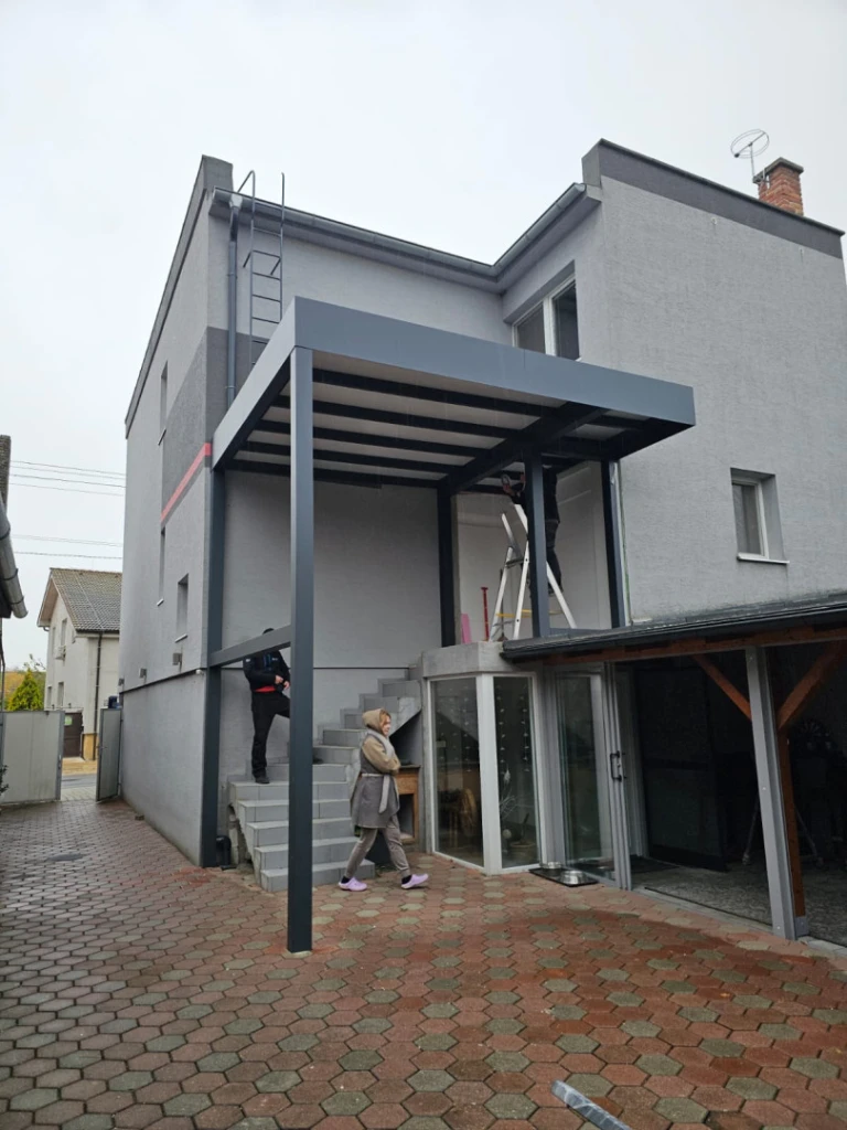 A modern gray aluminum pergola installed on the patio of a single-family home