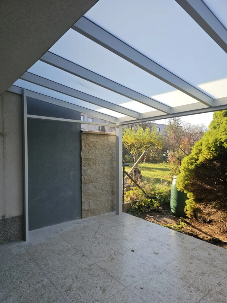 A modern aluminum pergola with a roof on the terrace of a single-family home