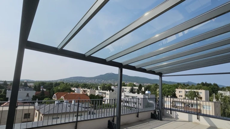 A modern aluminum pergola with a glass roof on a terrace overlooking Nitra and Zobor Hill