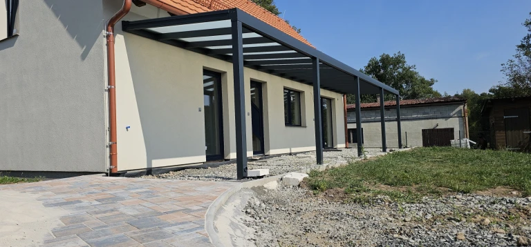 A modern ROBUST aluminum pergola with a glass roof installed on the patio of a single-family home