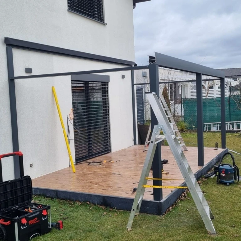 Installation of an aluminum structure for a sunroom on the patio of a single-family home.
