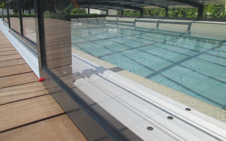 A close-up view of the railing and the structure of the low pool canopy on the wooden deck.