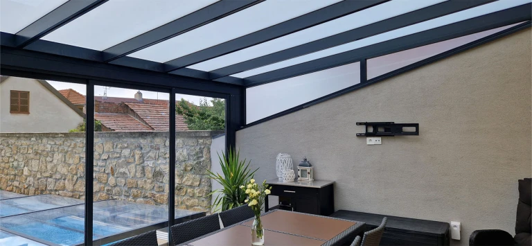 The modern interior of the ROBUST maintenance-free sunroom, featuring sliding glass doors and a view of the pool.