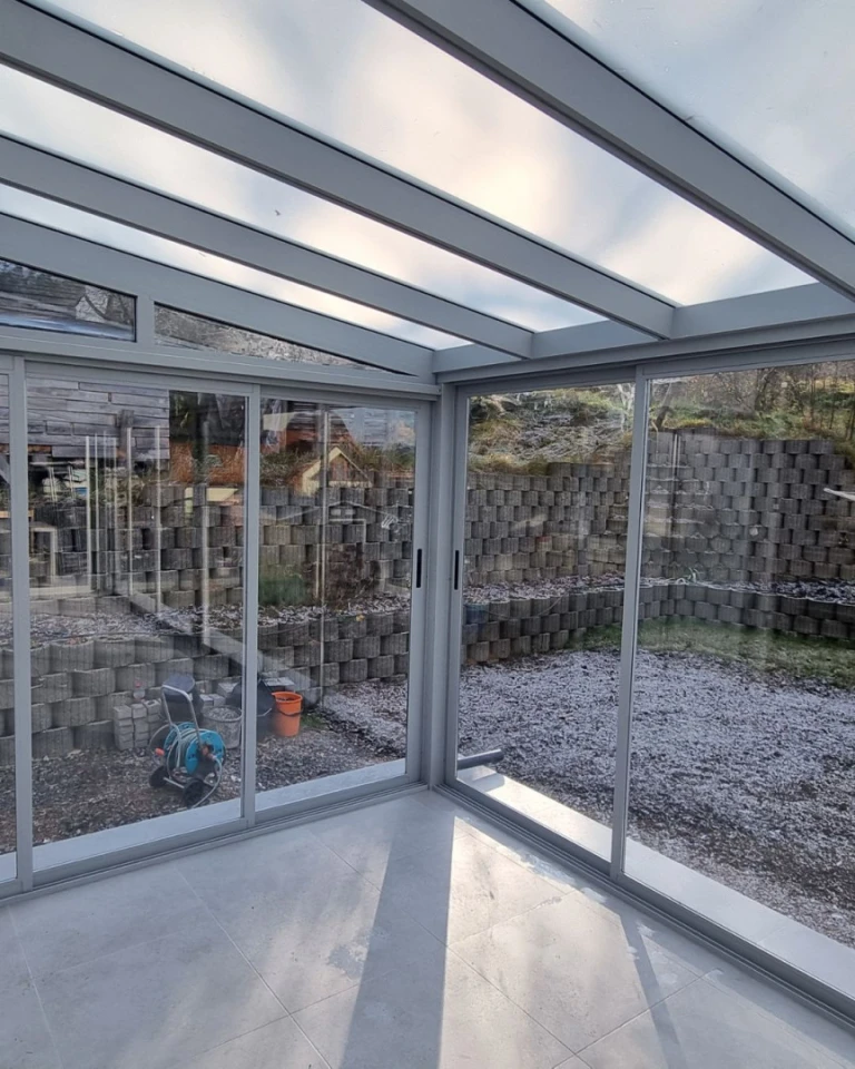 A detailed interior view of the glass structure of a sunroom with a view of the outdoors