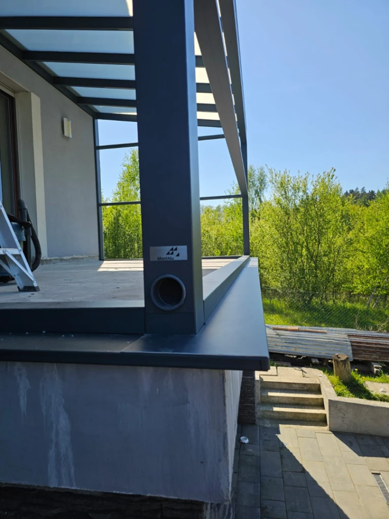 Close-up of the aluminum post and drain of a modern pergola on the patio
