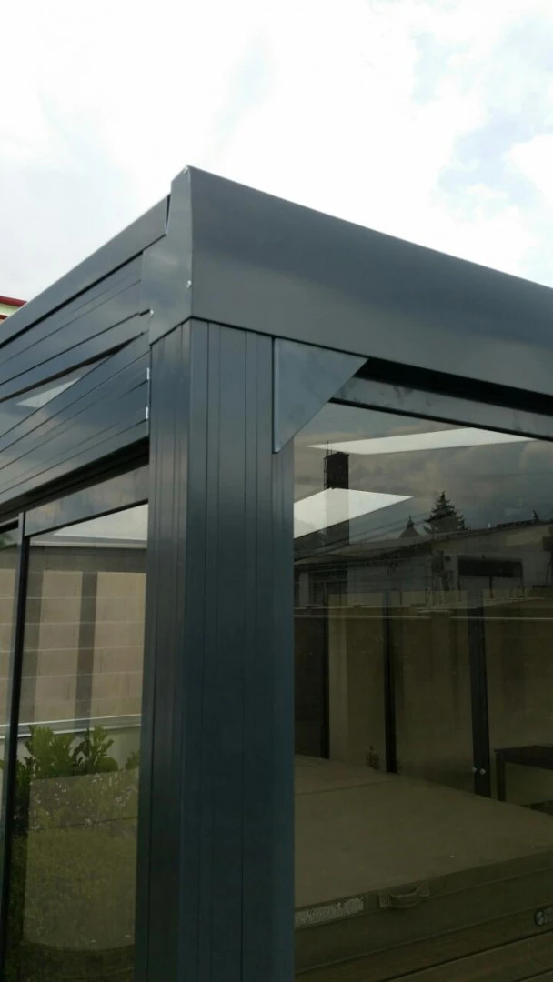 Close-up of the upper corner and glazing of a dark aluminum pergola
