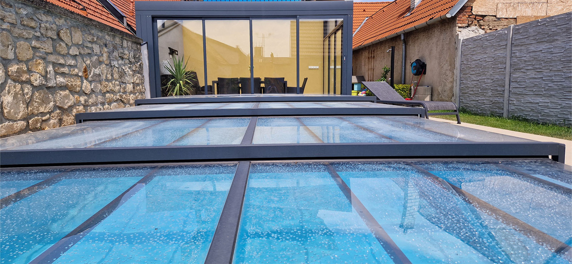 A close-up view of the low aluminum pool canopy with a modern gray frame in the backyard.