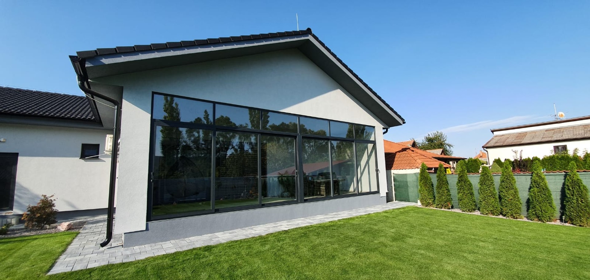 Modern patio glazing for a single-family home with gray frames and a view of the garden