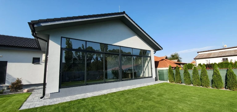 Modern patio glazing for a single-family home with gray frames and a view of the garden