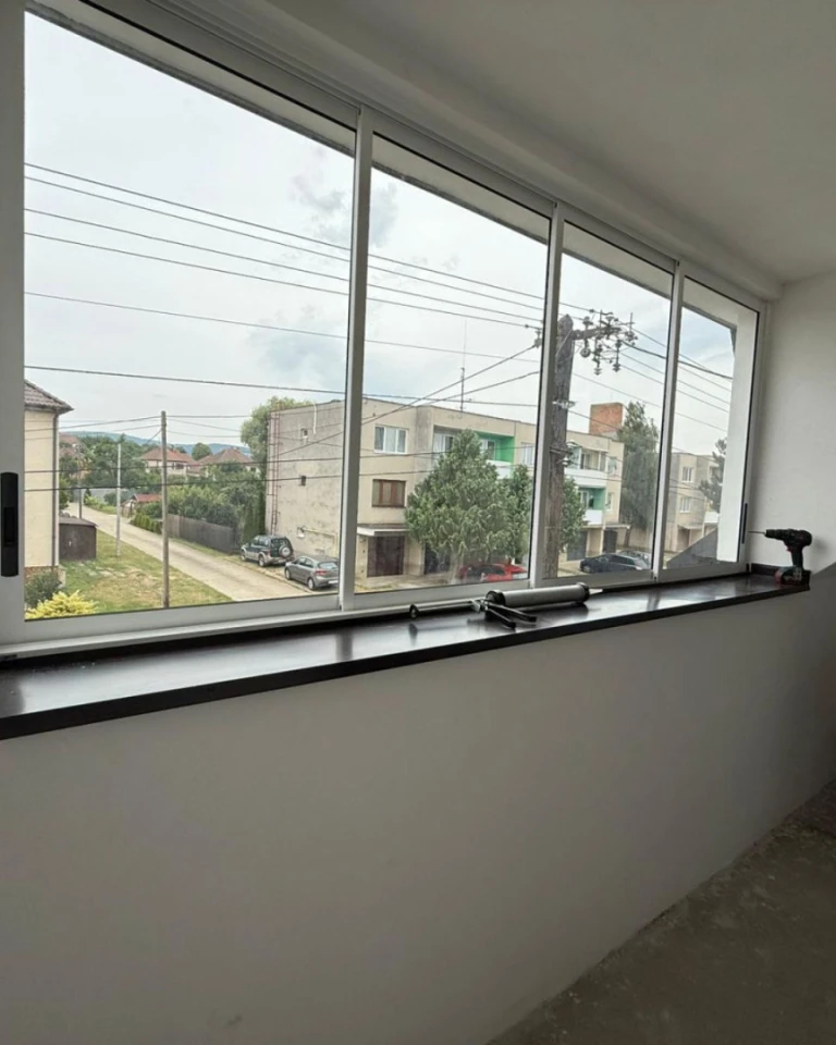 A view from inside of the newly installed sliding glass doors on the balcony overlooking the street.