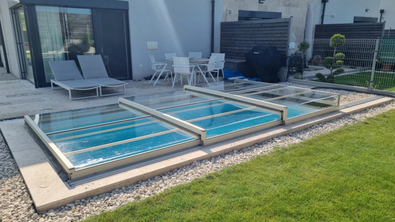 A modern, low-profile pool enclosure in the garden of a single-family home