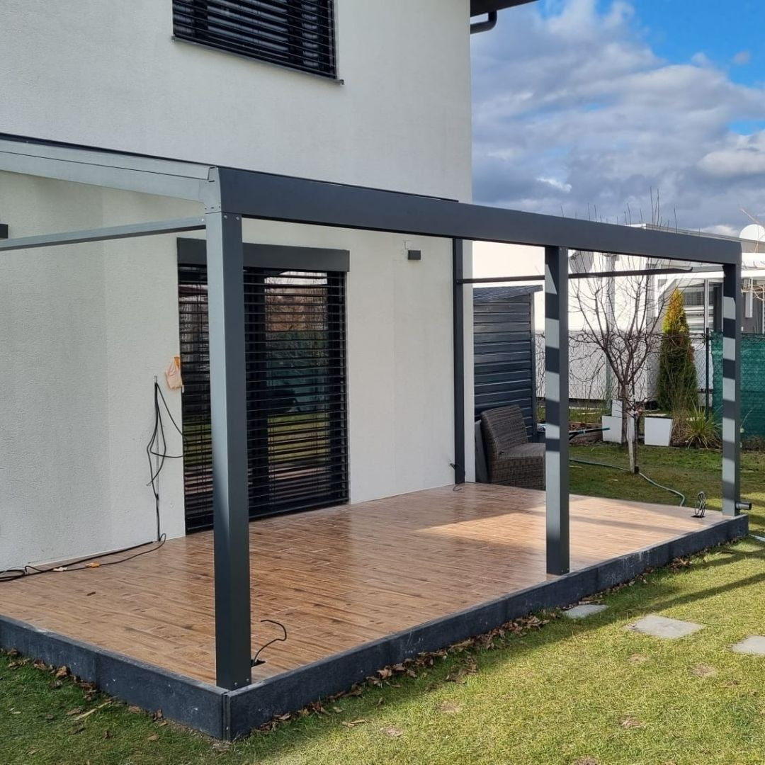 Construction of an aluminum sunroom on the wooden deck of a single-family home.