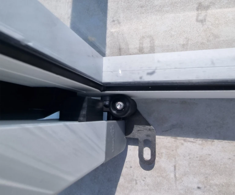 A detailed view of the guide mechanism and roller of the trackless pool enclosure