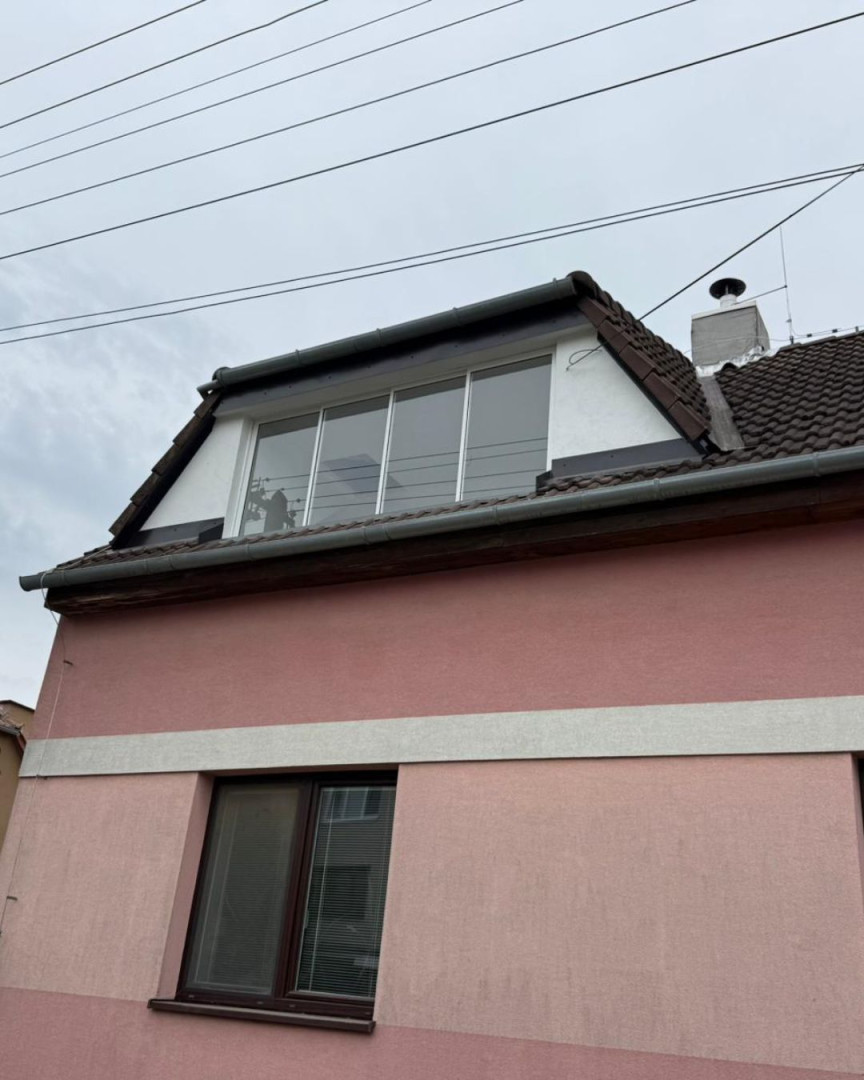 Glazing of the attic balcony in a pink single-family home