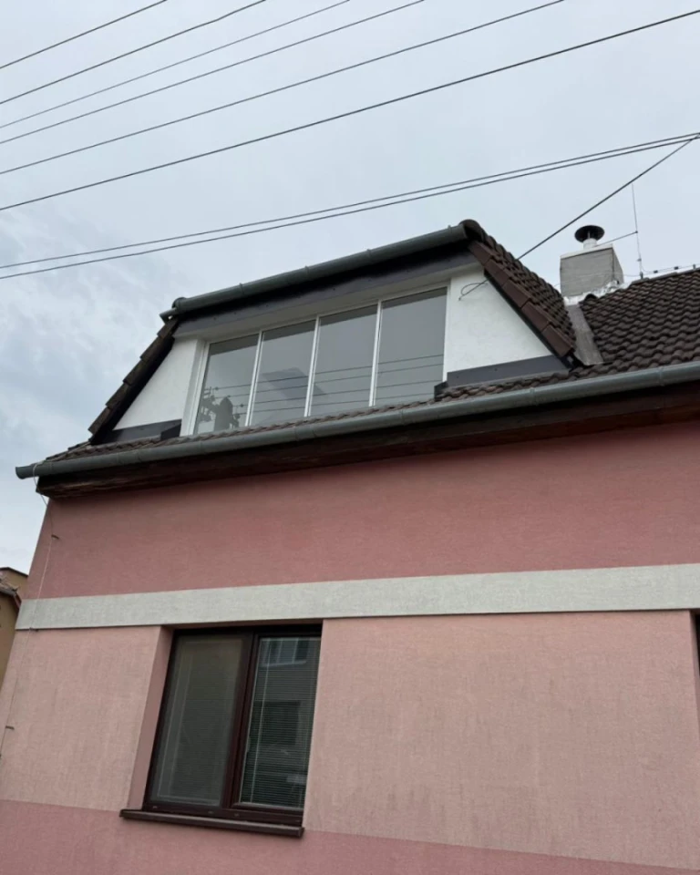 Glazing of the attic balcony in a pink single-family home