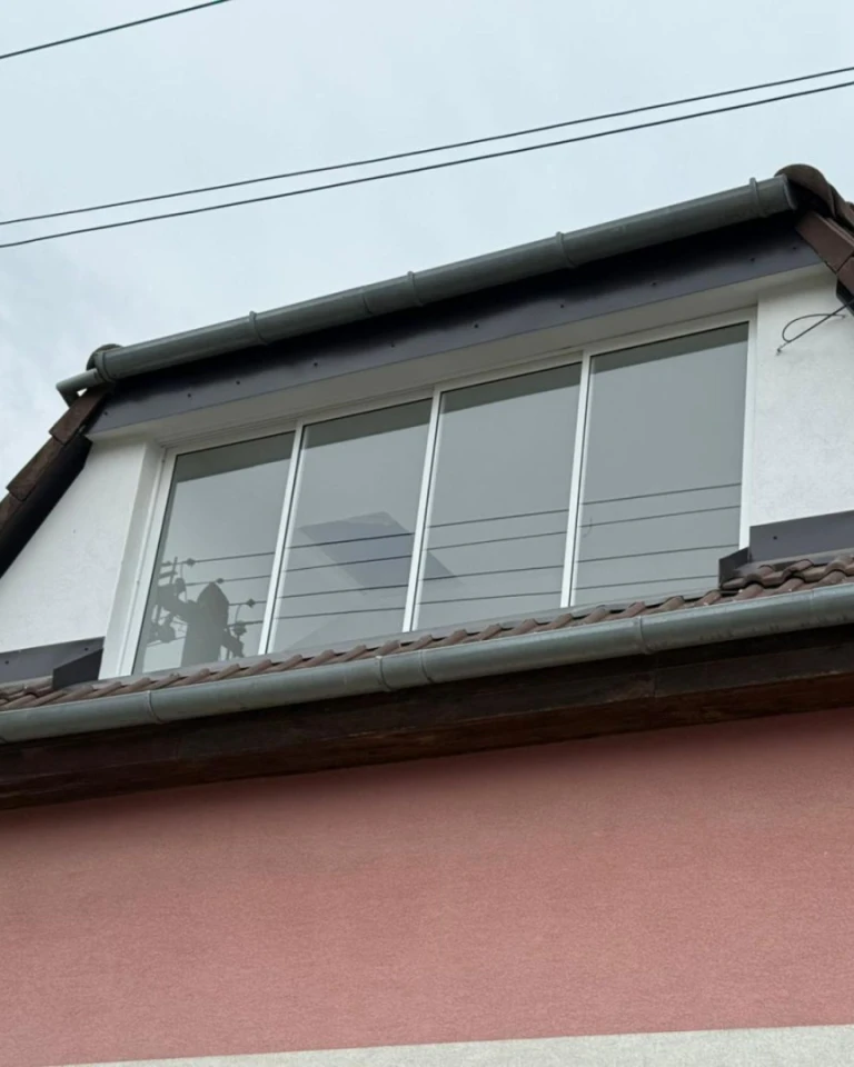 Modern frameless balcony glazing in the attic of a single-family home