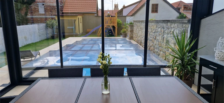View from the terrace of the covered pool in the backyard with a playground